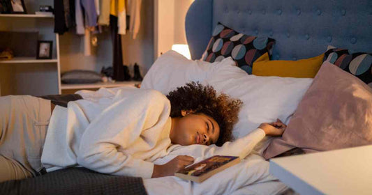 woman resting peacefully in a cozy bedroom with warm evening light representing emotional comfort and nighttime self-care relaxation