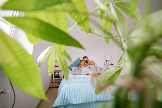 couple resting comfortably in a warm bedroom setting representing emotional and physical intimate wellness