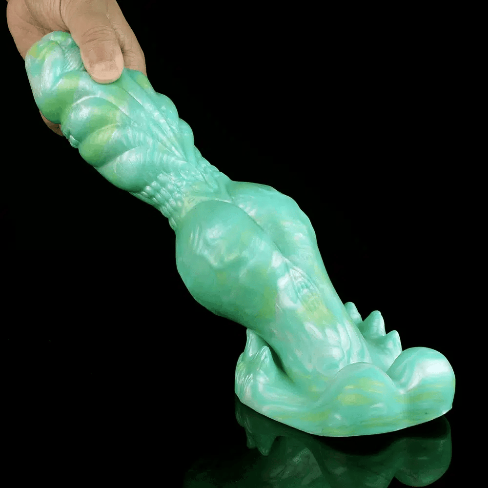 hand bending the cyan dragon dildo to show flexible silicone